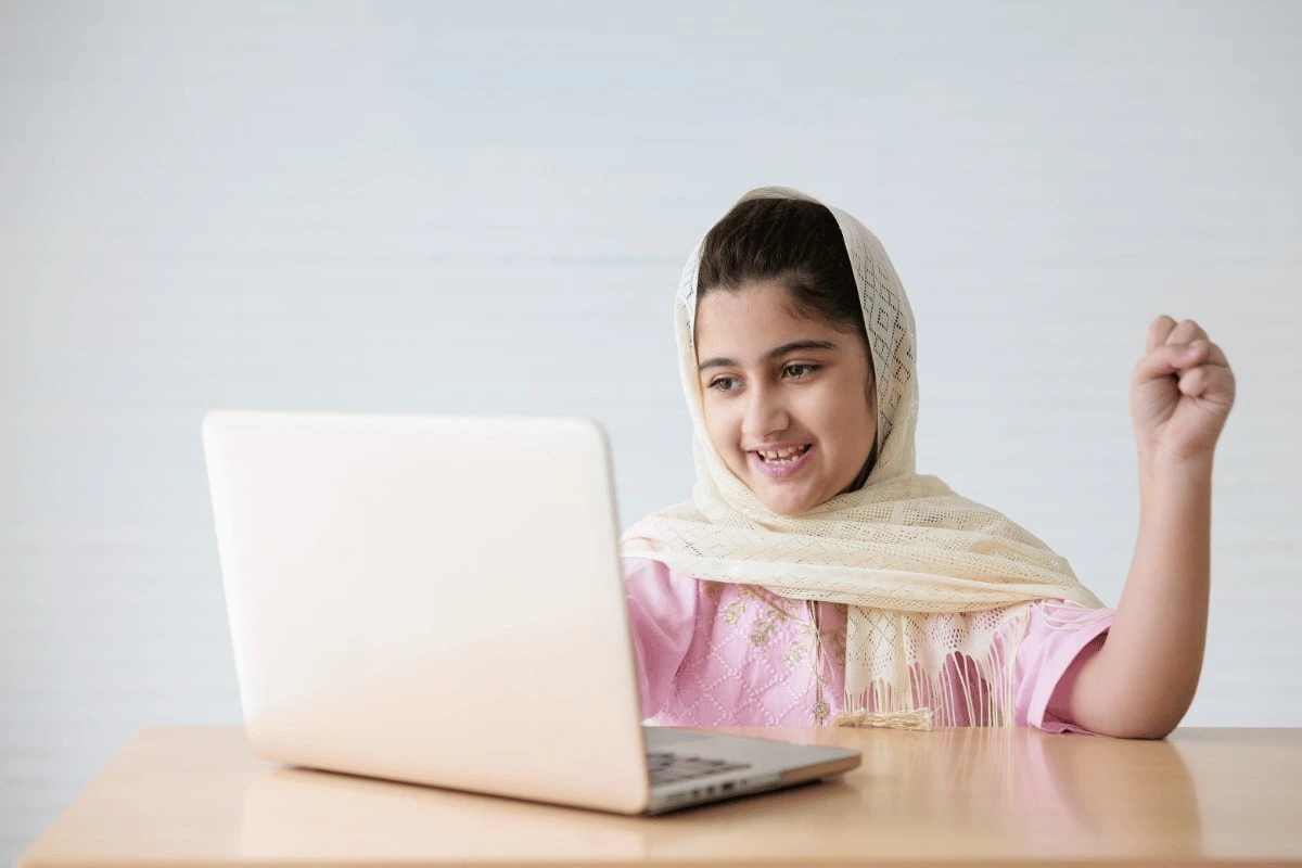 A child in a live online Quran lesson with a teacher at Al Hasan Online Quran Academy
