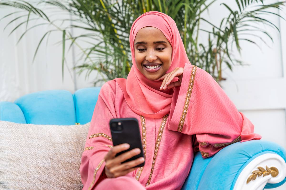 Muslim woman joining an online lesson on her smartphone at home