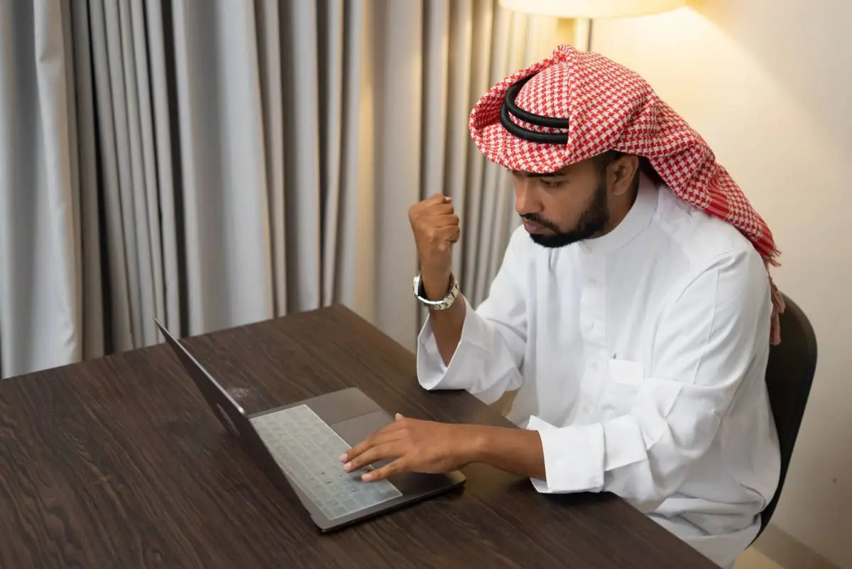 Muslim man attending a one-on-one online Quran lesson on a laptop