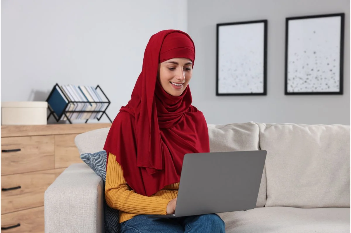 Muslim woman using a laptop while studying at home