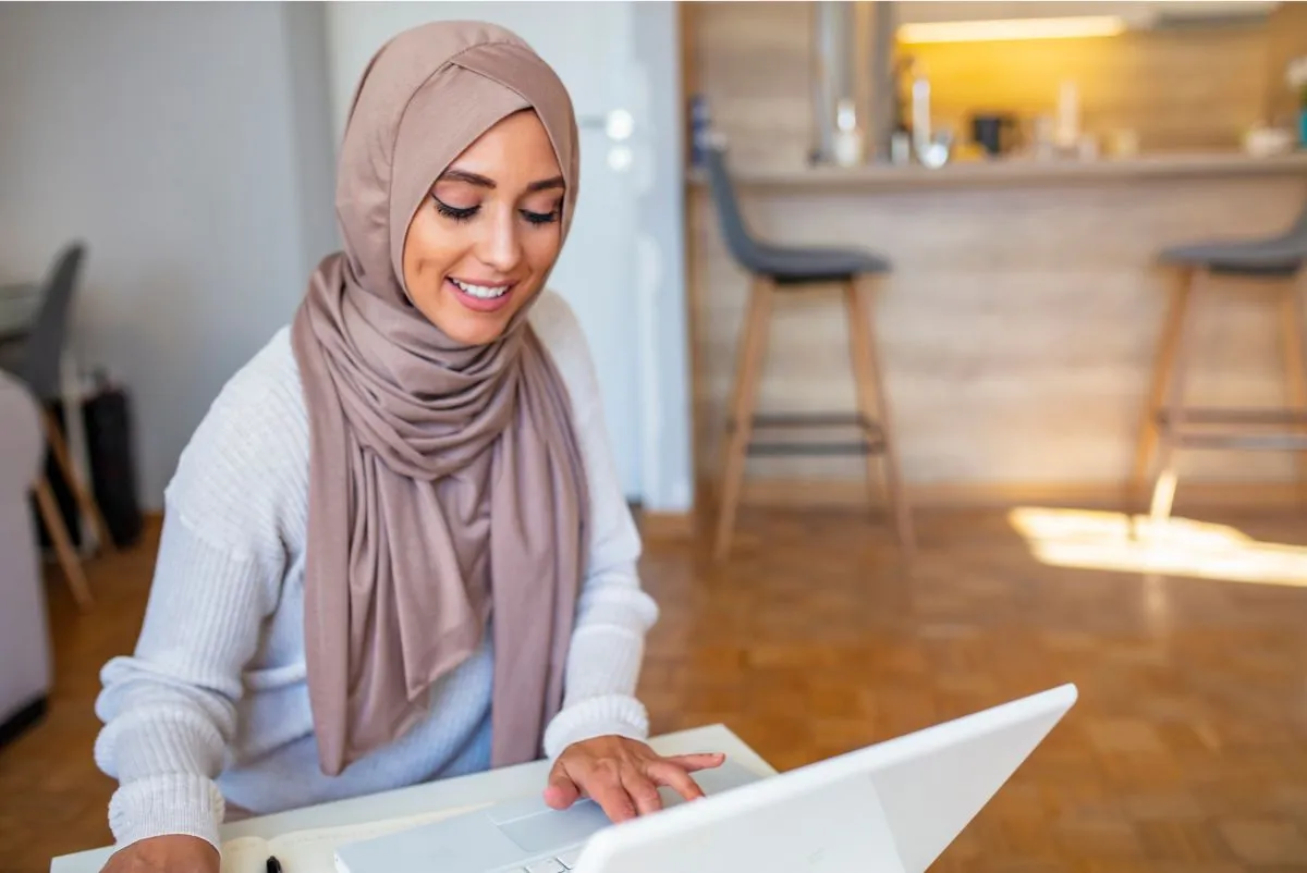 Adult Muslim woman attending an online Quran class at home
