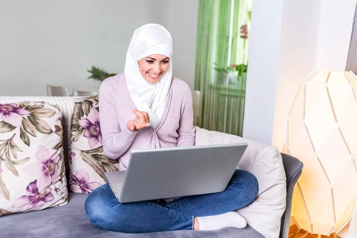 Muslim woman studying Quran online from home on a laptop