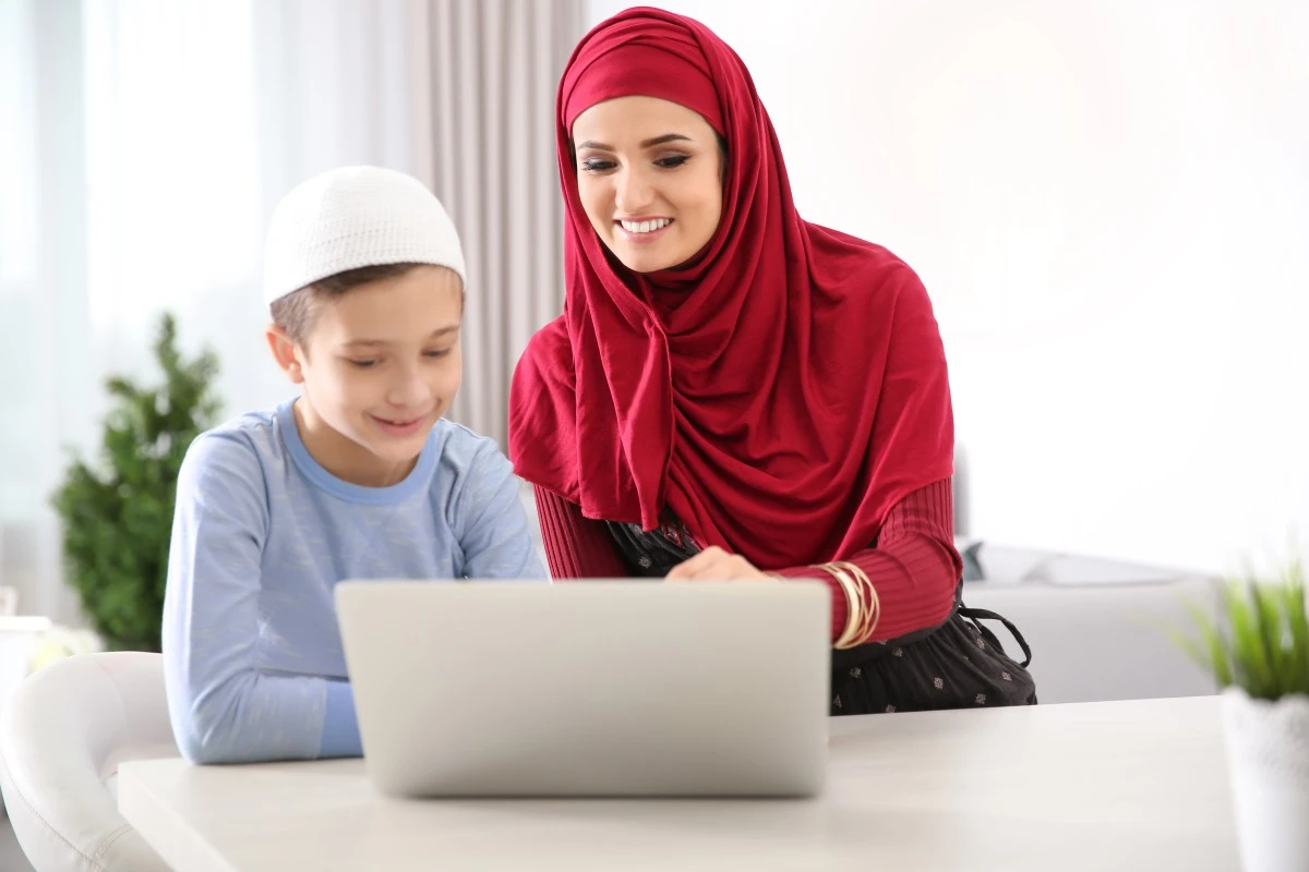 Mother helping her son during an online Quran class at home