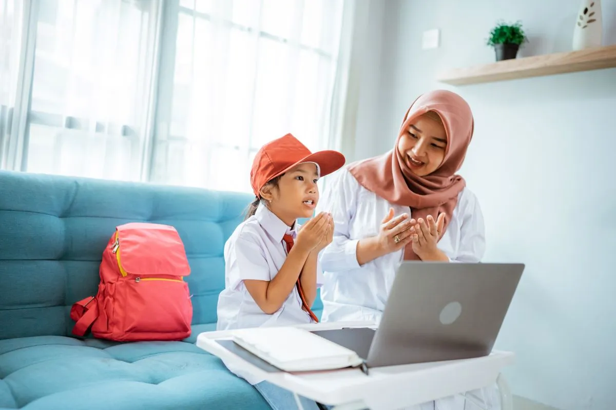 Mother supporting her daughter during an online Hifz class at home