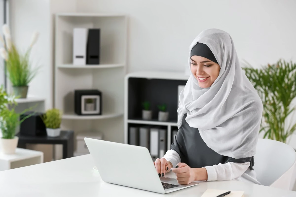 Muslim woman attending a private online Quran class on a laptop