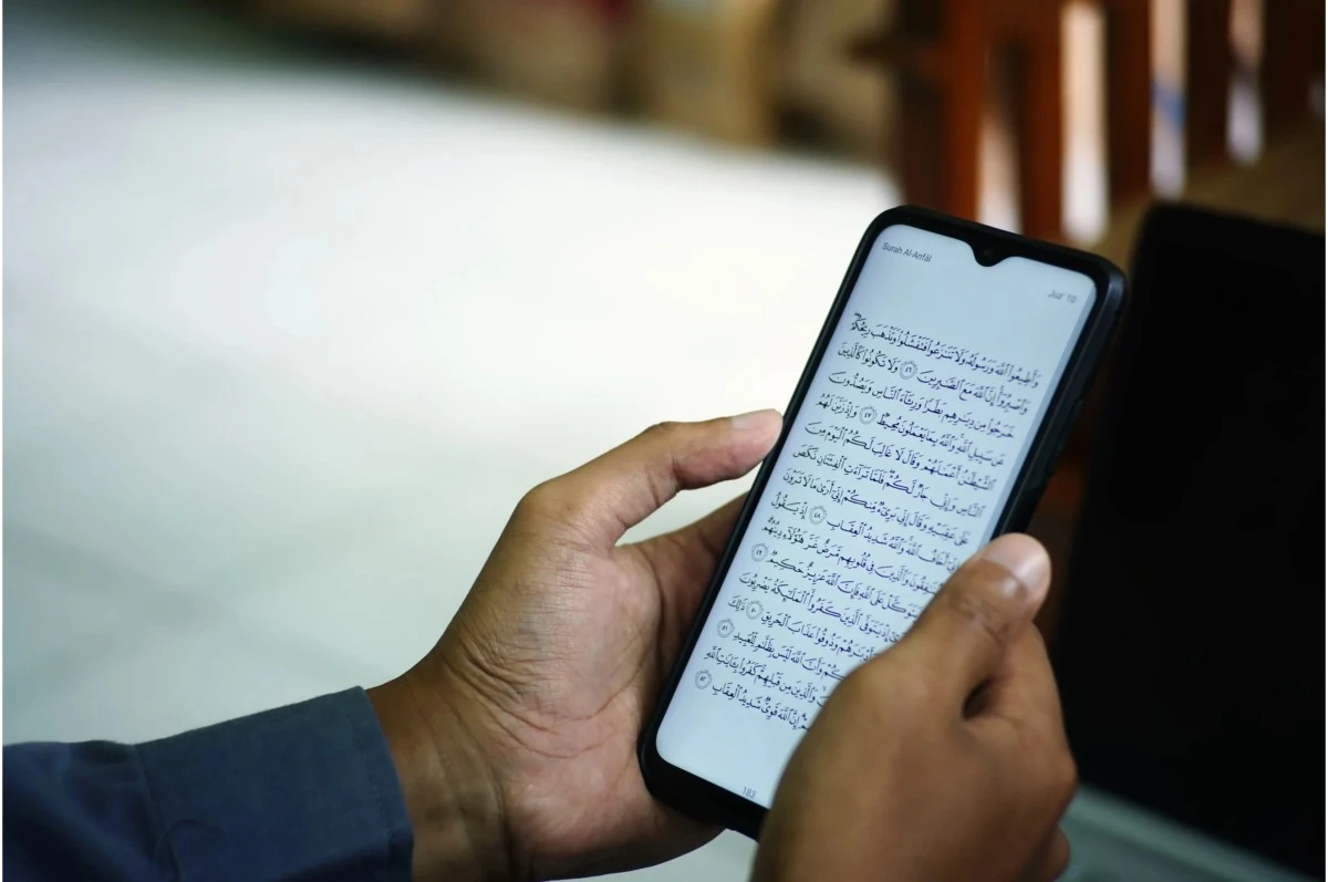 Person reading Quranic Arabic on a smartphone